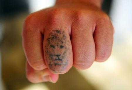 тату лев на пальце
