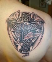 тату дракон держит кельтский крест