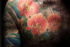 Тату веточка с тремя орхидеями на груди