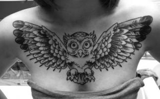 Татуировка в виде совы на груди девушки